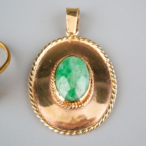 720 - Two jade items, to include a pendant set with an oval jade cabochon, within plain polished border an... 