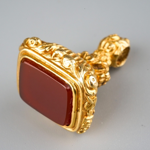 730 - A 9ct gold fob. Set with a carnelian, to the scroll embossed pedestal, hallmarked 9ct gold London 19... 