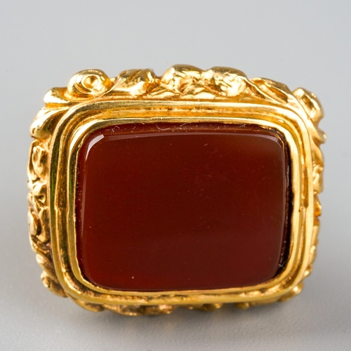 730 - A 9ct gold fob. Set with a carnelian, to the scroll embossed pedestal, hallmarked 9ct gold London 19... 