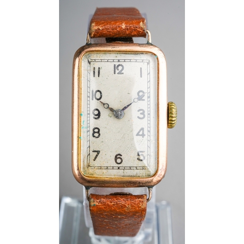 753 - A 1920s 9ct gold wristwatch. The rectangular silver dial with black Arabic numerals, blue steel hand... 