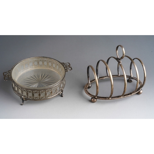 778 - A George V silver pierced circular butter dish holder, on four supports, opaque glass liner, the sil... 