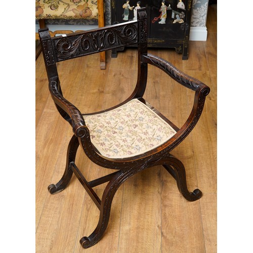 788 - A Savonarola X frame chair, carved back rail, arms and supports with floral decoration, upholstered ... 