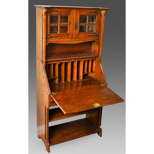 789 - An Arts & Crafts oak bureau bookcase, glazed upper section above slope front with fitted interior se... 