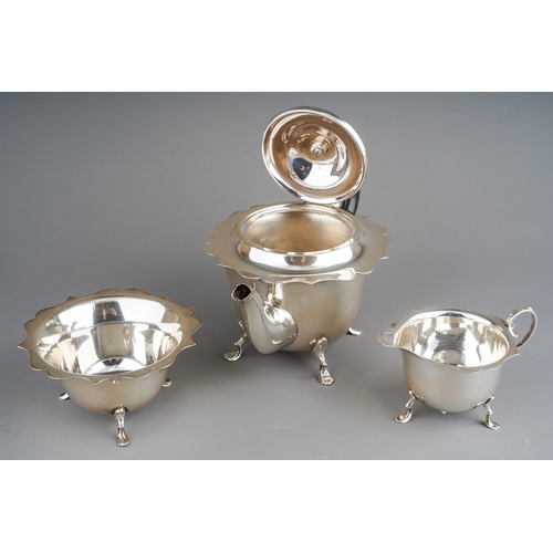 857 - A George V silver three piece bachelor's tea set, of circular form with wavy rims, on four cabriole ... 