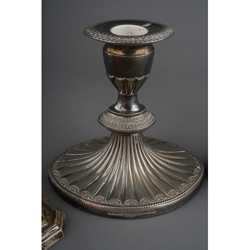 859 - A pair of George V silver dwarf candlesticks, square drip pans and stepped square loaded bases, lack... 