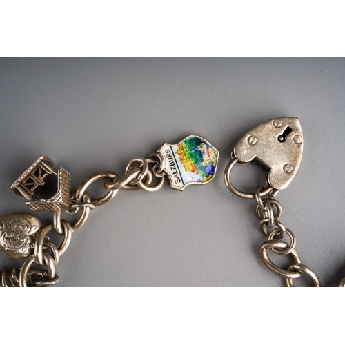 861 - Silver charm bracelet with various charms and heart shaped lock, gross weight approx 63g