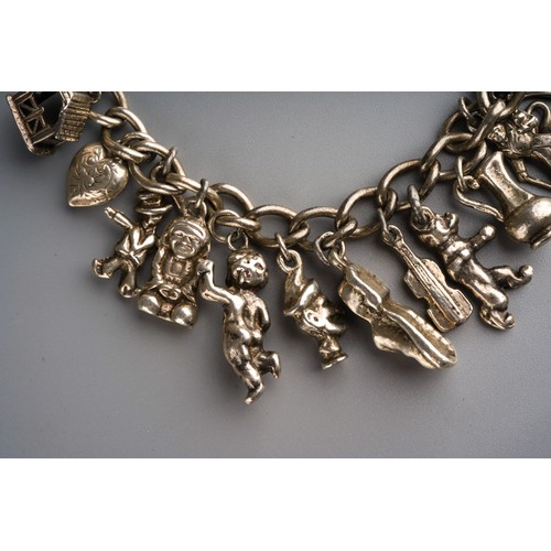 861 - Silver charm bracelet with various charms and heart shaped lock, gross weight approx 63g