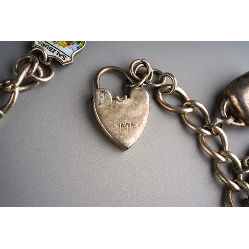 861 - Silver charm bracelet with various charms and heart shaped lock, gross weight approx 63g