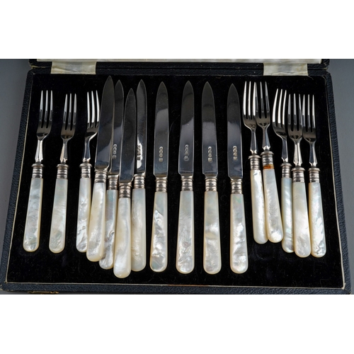 866 - A set of eight of George V silver mounted fruit knives and forks with mother-of-pearl handles, the t... 