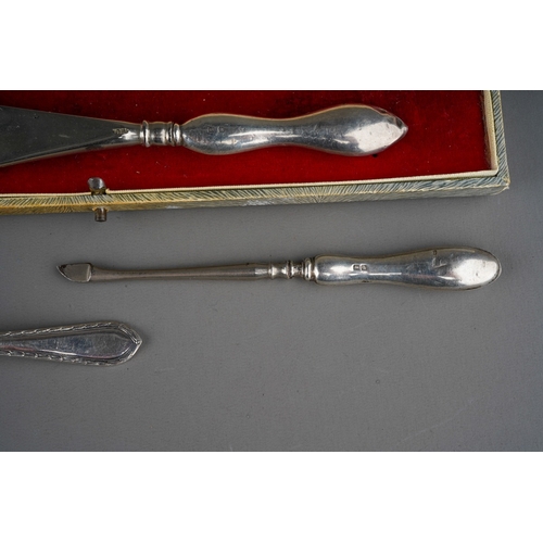 876 - Three pieces of silver, comprising a steel shoe horn with silver handle, a silver handled manicure t... 