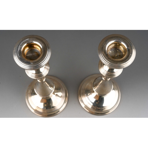 882 - A matched pair of silver candlesticks, with reeded knops, on raised bases, hallmarked by Barker & Co... 