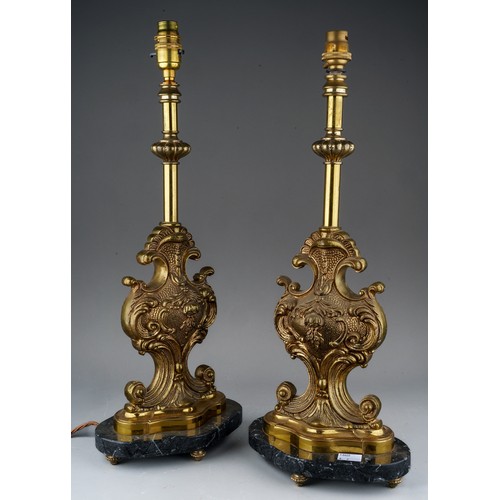 911 - A pair of French brass table lamps of scrolled foliate form, mounted on a shaped oval grey marble pl... 