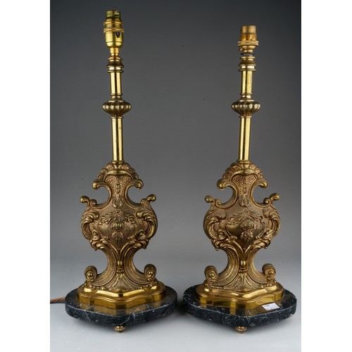 911 - A pair of French brass table lamps of scrolled foliate form, mounted on a shaped oval grey marble pl... 