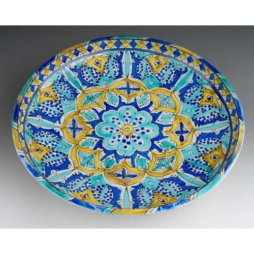 961 - An early 20th century Morrocan tin glaze earthenware shallow dish, decorated with geometric designs ... 