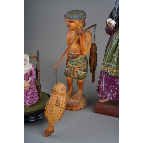 964 - A carved wooden figure of an Indian /Eastern fisherman carrying two fish on a removable pole, height... 