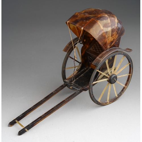 966 - A tortoiseshell and yellow metal mounted rickshaw, one wheel with damage,  height 10cm x length 14cm... 