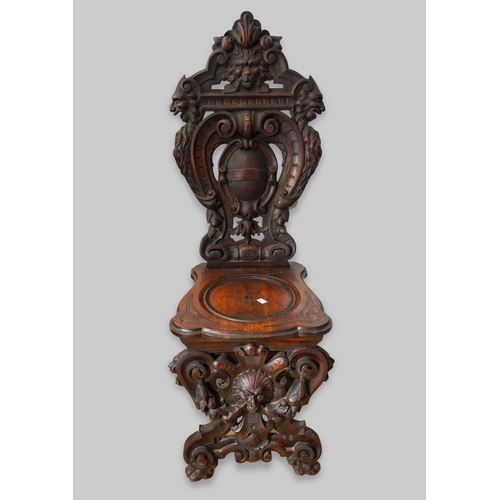 997 - A late 19th century walnut sgabello chair, the back ornately carved with lion masks and central scro... 