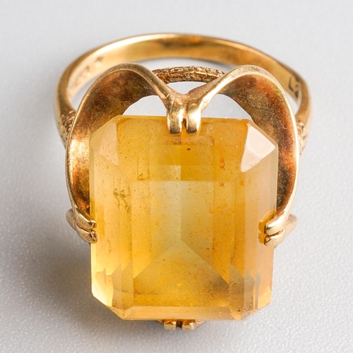 1004 - A 1970s 9ct gold citrine single stone ring. Set with a rectangular citrine, within a double four cla... 