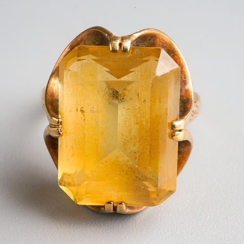 1004 - A 1970s 9ct gold citrine single stone ring. Set with a rectangular citrine, within a double four cla... 