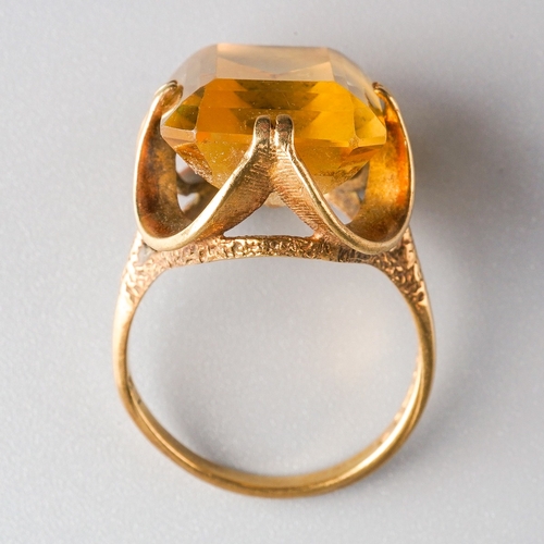 1004 - A 1970s 9ct gold citrine single stone ring. Set with a rectangular citrine, within a double four cla... 