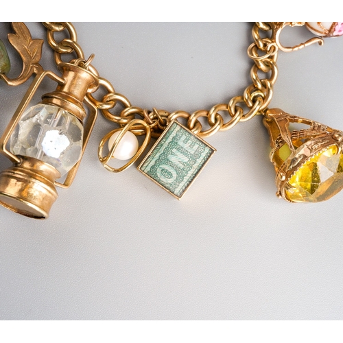 1011 - A gold charm bracelet. The solid curb link chain with scroll embossed padlock, suspending a series o... 