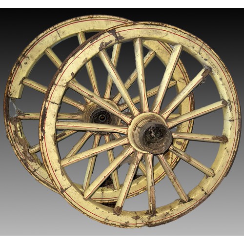 180 - A pair of wooden cart wheels in cream, in need of clean, approx. 77 cm in diameter