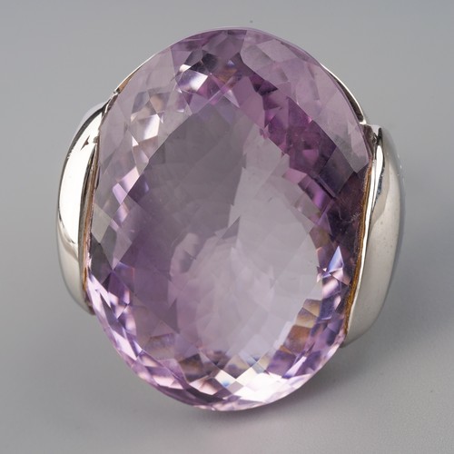 712 - An amethyst and diamond dress ring, set with a top faceted amethyst to the diamond set sides, ring s... 