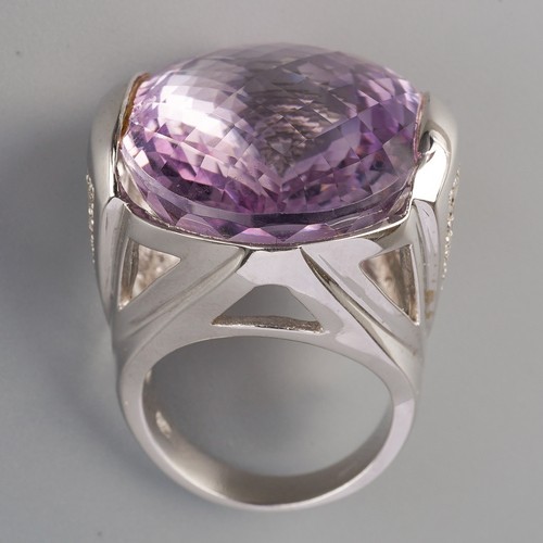 712 - An amethyst and diamond dress ring, set with a top faceted amethyst to the diamond set sides, ring s... 