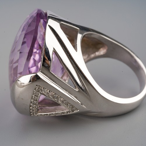 712 - An amethyst and diamond dress ring, set with a top faceted amethyst to the diamond set sides, ring s... 