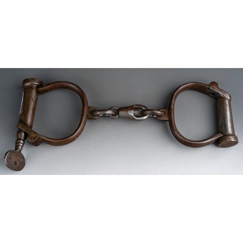 926 - A pair of early 20th century Hiatt Wrought Iron Handcuffs numbered 153 with screw-fitting key attach... 