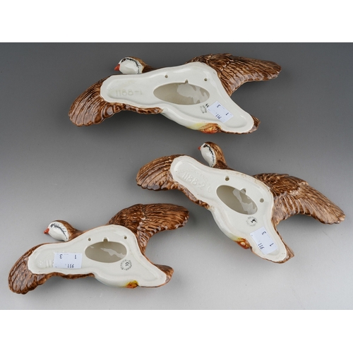 21 - A graduated set of three Beswick flying pheasant wall plaques, model nos 1188-1, 1188-2 and 1188-3, ... 