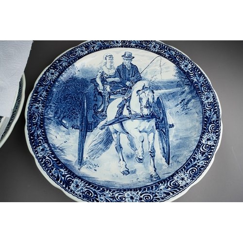 35 - Six large blue and white Delft chargers by Boch with Dutch landscapes, a deer hunt and a couple in a... 