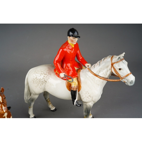 115 - A collection of Beswick Hunting figures comprising Huntsman on grey horse af, girl on pony, two foxe... 