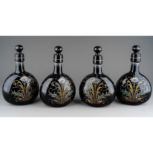 122 - A set of four 19th century dark coloured glass decanters of flattened ovoid form, all with stoppers,... 