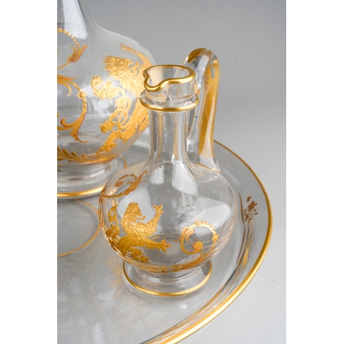 133 - An early 20th century Baccarat clear glass and gilt three piece decanter and jar set on circular tra... 