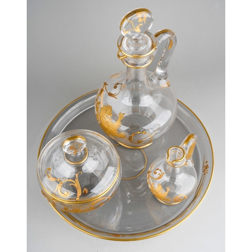 133 - An early 20th century Baccarat clear glass and gilt three piece decanter and jar set on circular tra... 