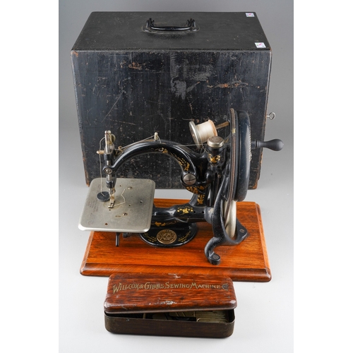 241 - An early 20th century Willcox & Gibbs table top manual sewing machine with arched arm, mounted on a ... 