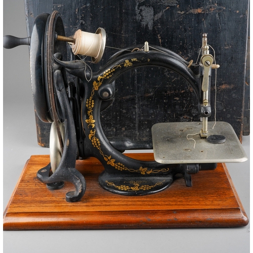 241 - An early 20th century Willcox & Gibbs table top manual sewing machine with arched arm, mounted on a ... 