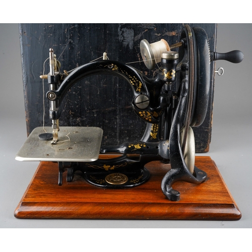 241 - An early 20th century Willcox & Gibbs table top manual sewing machine with arched arm, mounted on a ... 