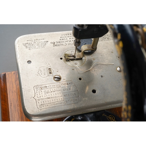 241 - An early 20th century Willcox & Gibbs table top manual sewing machine with arched arm, mounted on a ... 