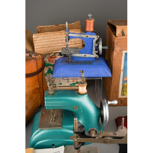 242 - Four vintage Child`s sewing machines including a blue boxed 