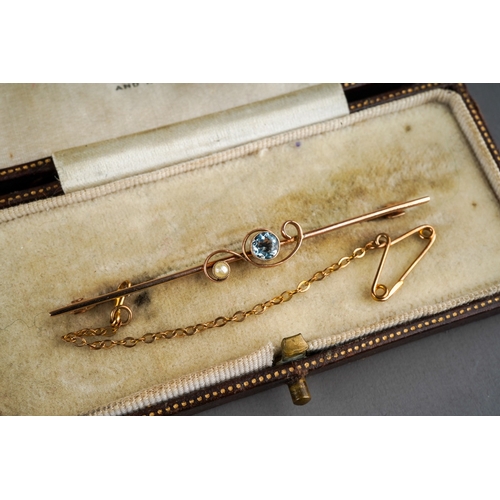 500 - An early 20th century 9ct gold bar brooch. Set with an aquamarine and split pearl, with antique case... 