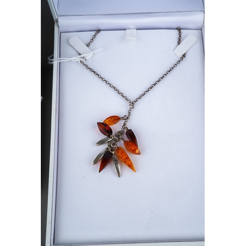 503 - Three items of boxed modern silver and amber jewellery, comprising two necklaces and one bracelet al... 