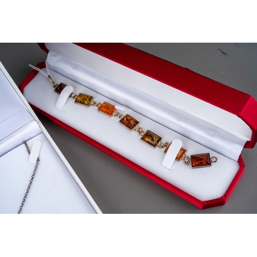 503 - Three items of boxed modern silver and amber jewellery, comprising two necklaces and one bracelet al... 