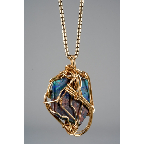 508 - A hardstone pendant with chain, the hardstone displaying green, blue and red colours, mounted within... 