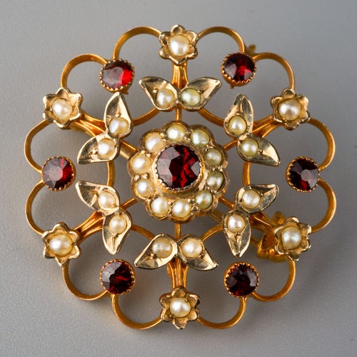 510 - An Edwardian 9ct gold garnet and seed pearl brooch. Of openwork design, set with garnet and seed pea... 