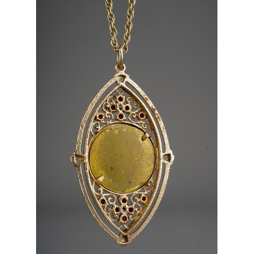 636 - A yellow metal gem set pendant with chain, the pendant set with a central metal panel, with garnet a... 