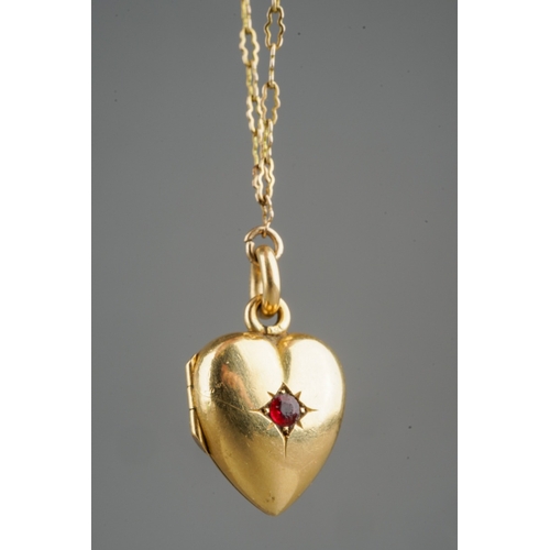 682 - 18 ct gold hear locket set with a ruby on a rolled gold chain, gross weight of heart locket 4.8g