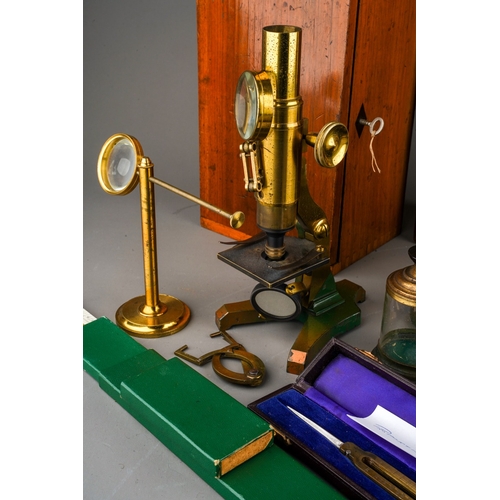 880 - A box containing a collection of scientific instruments, including two late 19th/ early 20th century... 