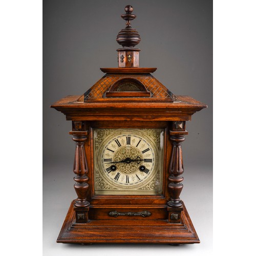 884 - A German oak cased mantle clock, silvered dial with Roman numerals, Architectural case with turned s... 